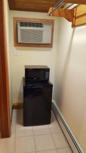a small refrigerator in a room with a air conditioner at Atlantic Motel in Point Pleasant Beach