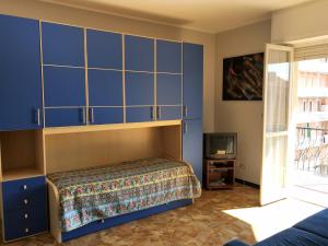 - une chambre avec des armoires bleues et une télévision dans l'établissement House Roxana by Holiday World, à San Bartolomeo al Mare