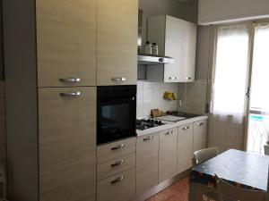 een keuken met witte kasten en een fornuis met oven bij House Roxana by Holiday World in San Bartolomeo al Mare
