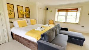 a bedroom with a large bed and a couch at Estatesmen Lodge, Hillside Farm in Kirkby Stephen