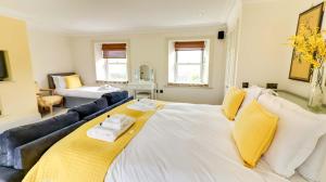 a large white bed in a room with a couch at Estatesmen Lodge, Hillside Farm in Kirkby Stephen