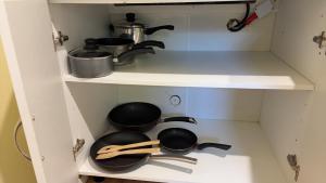 a cupboard with pots and pans and utensils at Ke's home in Wellington +6 photos
