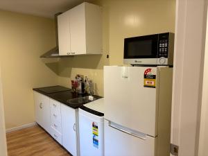a kitchen with a white refrigerator and a microwave at Ke's home in Wellington
