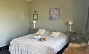 a bedroom with a white bed with two towels on it at la ferme au bois dormant in Wemaers-Cappel