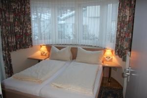 a bed in a room with two lamps on tables at Waldschlössl in Latschach ober dem Faakersee