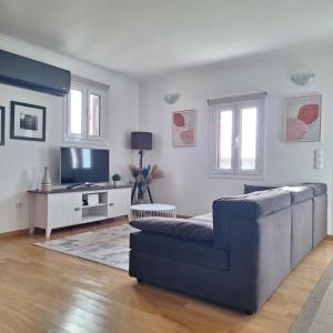 a living room with a couch and a tv at Philoxenia Home in Áyios Pétros