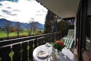 a table on a balcony with a view of the mountains at Alpenflair Ferienwohnungen Whg 205 in Oberstdorf