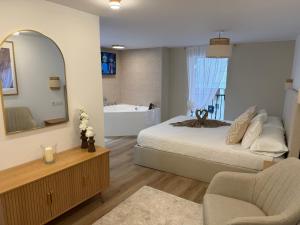 a bedroom with a bed and a mirror and a tub at El Rincón de Mateo in Combarro