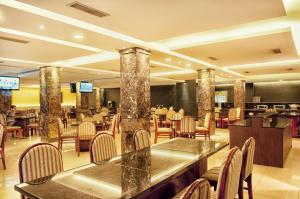a restaurant with tables and chairs and a lobby at Grand Sakura Hotel in Medan