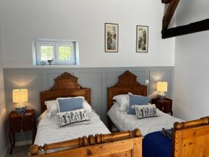 a bedroom with two beds with blue and white pillows at Georgie et Margot - Chambres d'hotes et Gite in La Châtre-Langlin