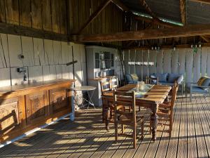 a wooden table and chairs on a deck at Georgie et Margot - Chambres d'hotes et Gite in La Châtre-Langlin