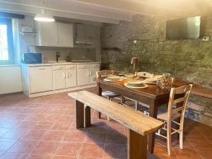 a kitchen with a wooden table and a wooden bench at Quercus La Baita in La Verna