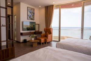 a hotel room with a bed and a chair at Mia Beach Hotel in Cù Lao Thu