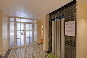 a hallway with a walk in shower and a tile wall at Treebo Green Pearl Inn in Guwahati +39 photos