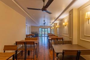 a row of tables and chairs in a restaurant at Treebo Green Pearl Inn in Guwahati