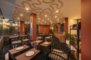 a restaurant with tables and chairs and a ceiling at Echor Alpine Meadows Khajjiar Dalhousie in Khajjiar 
