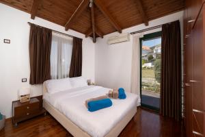a bedroom with a white bed and a large window at Ever Eden Residence by A&D Properties in Porto Rafti +86 photos