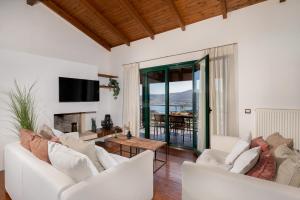 a living room with white furniture and a fireplace at Ever Eden Residence by A&D Properties in Porto Rafti