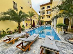 a swimming pool with chaise lounges next to a building at Tam Coc Holiday Hotel & Spa in Ninh Binh
