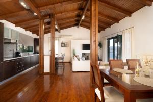 a kitchen and living room with a table and chairs at Ever Eden Residence by A&D Properties in Porto Rafti