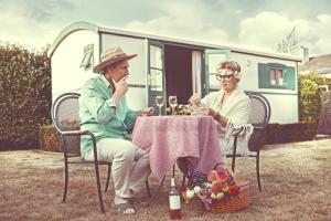 two older women sitting at a table in front of a rv at Jardin Jannik in Watou