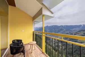 a balcony with a table and a chair and a view at Echor Alpine Meadows Khajjiar Dalhousie in Khajjiar 