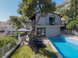 a house with a swimming pool and a tree at Ever Eden Residence by A&D Properties in Porto Rafti
