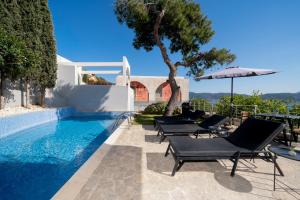 a swimming pool with lounge chairs and an umbrella at Ever Eden Residence by A&D Properties in Porto Rafti
