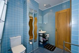 a blue tiled bathroom with a toilet and a sink at Apartments in downtown in Lisbon +49 photos