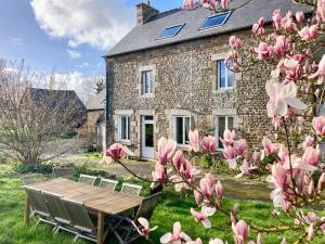 a house with pink magnolia trees in front of it at La Breizhidence in Combourg