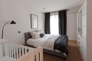 a white bedroom with a bed and a window at Rooftop Spa Villa Kuressaare in Kuressaare +58 photos