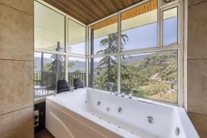 a large bath tub in a room with large windows at Echor Alpine Meadows Khajjiar Dalhousie in Khajjiar 