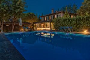 una piscina di fronte a una casa di notte di Casanova di Pescille a San Gimignano