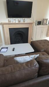 a living room with a couch and a tv on a fireplace at Balfour house III in Leicester