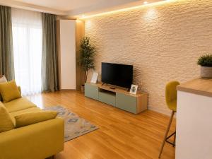 a living room with a flat screen tv on a wall at Liberty Deluxe Apartment Cosmopolis in Creţuleasca