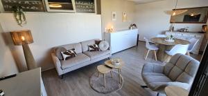 a living room with a couch and a table at Bon Diaz at Sea in Julianadorp