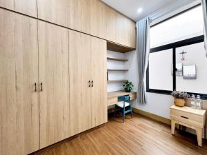 an office with wooden cabinets and a desk and a window at ECHO VILLA PHAN THiET in Phan Thiet +13 photos