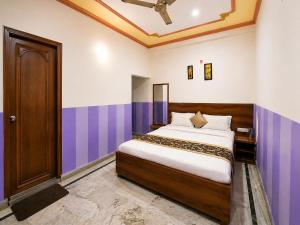a bedroom with a bed with purple and white walls at Hotel Rudra Ganga View Near Temple in Varanasi