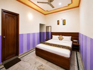 a bedroom with a bed with purple and white walls at Hotel Rudra Ganga View Near Temple in Varanasi