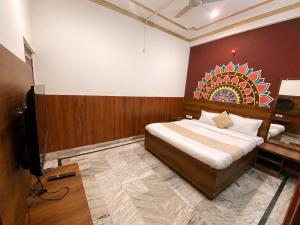 a bedroom with a bed with a painting on the wall at Hotel Rudra Ganga View Near Temple in Varanasi