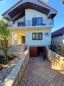 a house with a stone walkway in front of it at Casa Livia in Tuzla