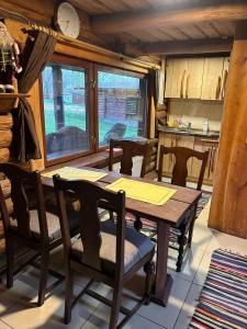 a dining room with a wooden table and chairs at Pūnas Sauna in Lenči