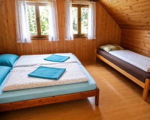 a bedroom with two beds in a wooden house at Chata Růžová in Růžová