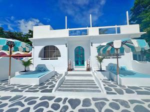 a white house with two chairs and umbrellas at Casa di Stella in Ngurblut