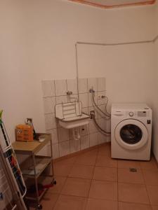 a laundry room with a washing machine and a sink at Hunsrücktraum in Mittelstrimmig