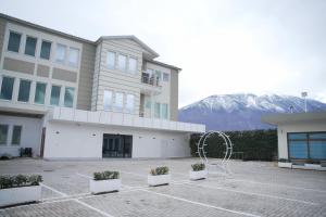 a building with a lot of plants in a parking lot at Hotel haliti kukes in Kukës