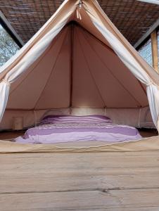 a bed in a tent with a canopy at Macarìa Agricampeggio in Alliste