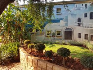 a house with a garden in front of it at Homestay Travel Guest House in Roodepoort