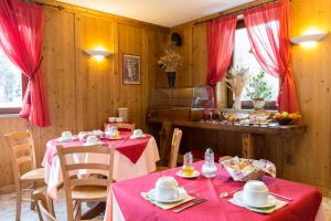 a dining room with two tables with red table cloth at Residence Les Nigritelles in Cogne