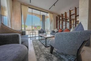 a living room with two couches and a table at Belmar Inn Apartments in Jazan